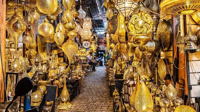 Golden Moroccan brass lanterns glowing in a traditional Marrakech souk, showcasing Moroccan craftsmanship and vibrant culture.