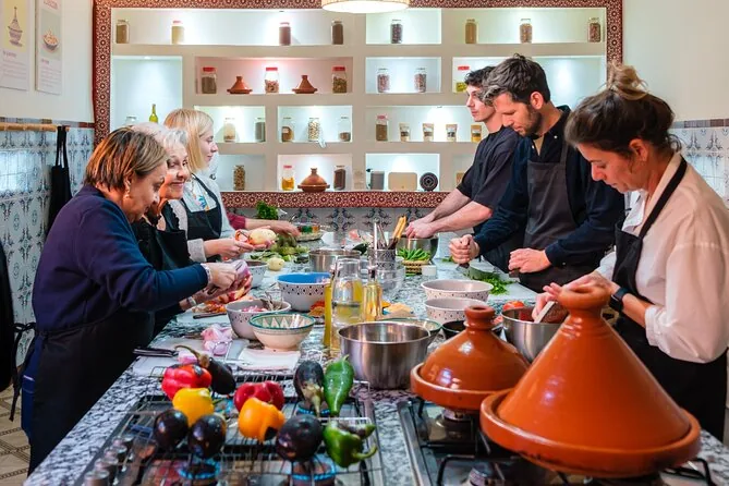Participants preparing vegetables beside rows of clay tagines