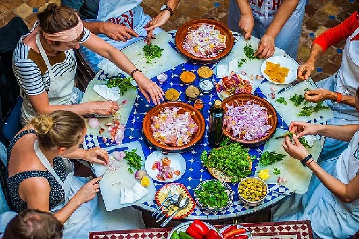 Group chopping fresh ingredients around a zellige table in a riad