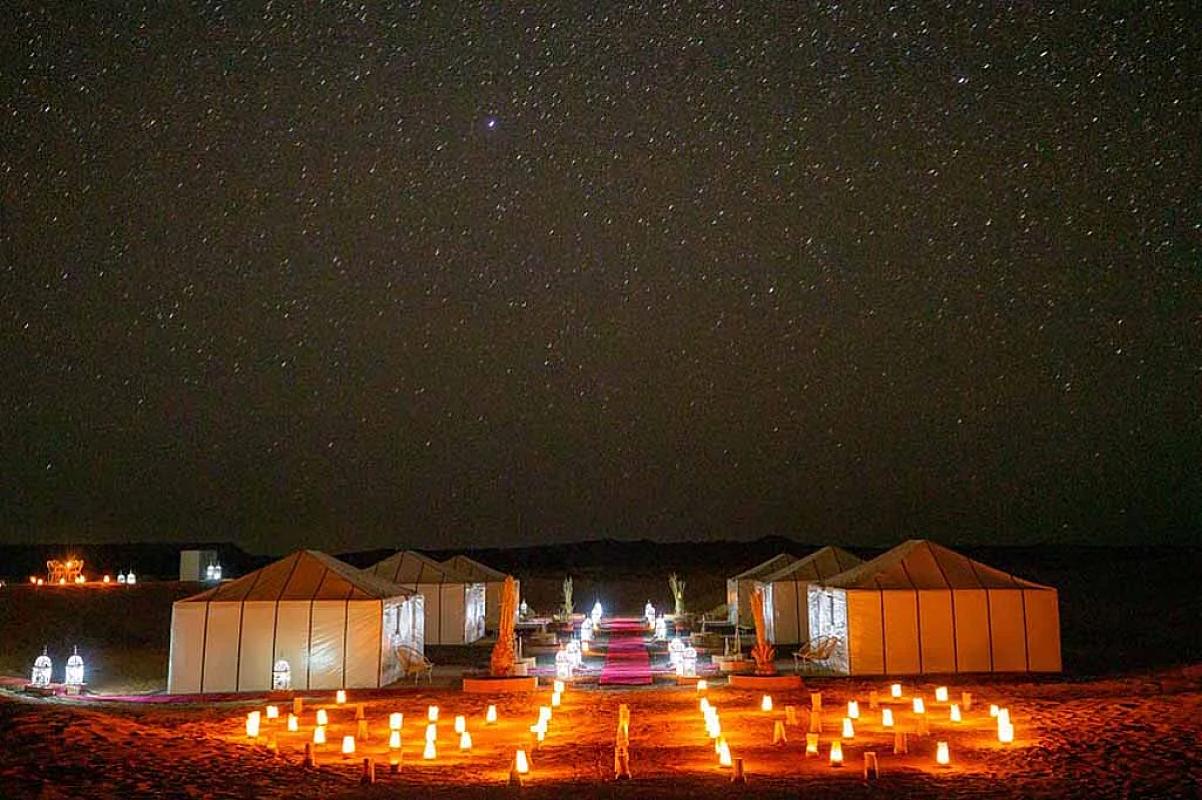 Candle-lit desert camp beneath a star-filled Sahara sky