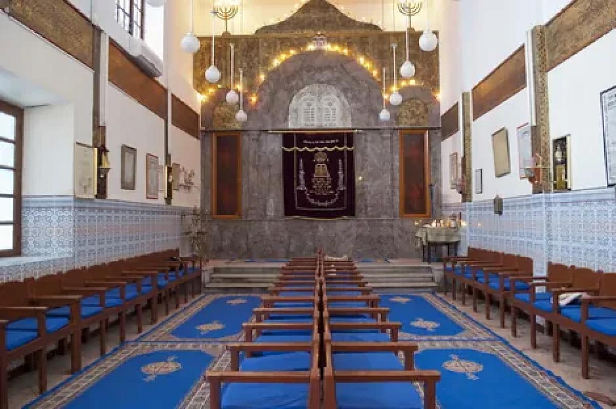 Blue benches and gilded ark inside the Lazama synagogue