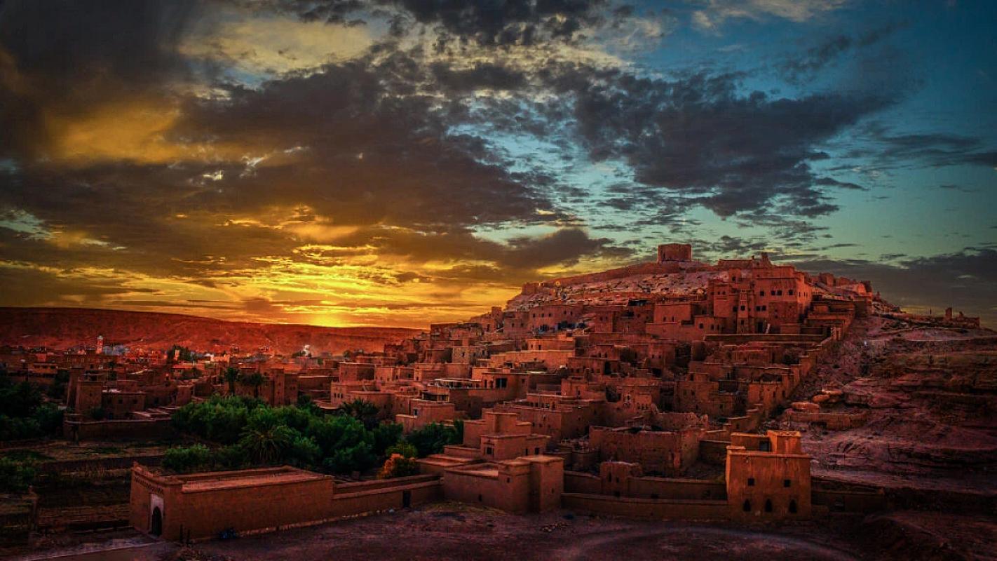 Ait Benhaddou ksar above palm groves in warm sunset light