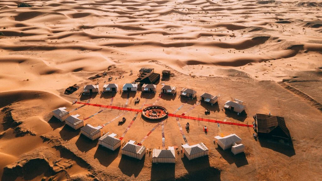 Aerial view of a circular desert camp among the Merzouga dunes