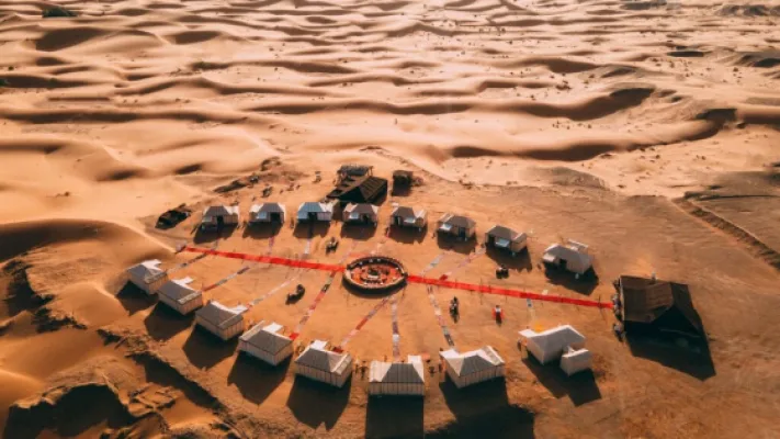 Aerial view of a circular desert camp among the Merzouga dunes