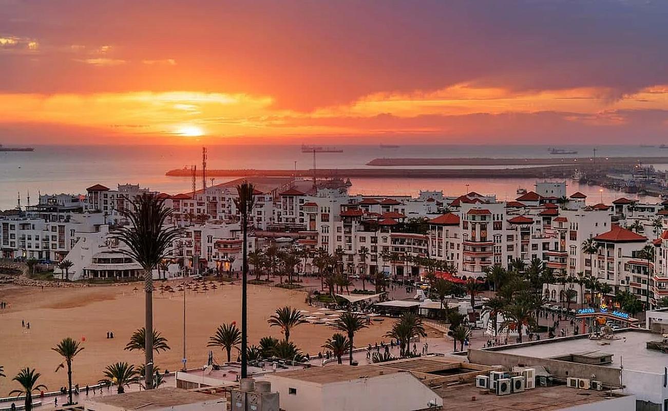 Agadir marina and promenade under an orange sunset sky