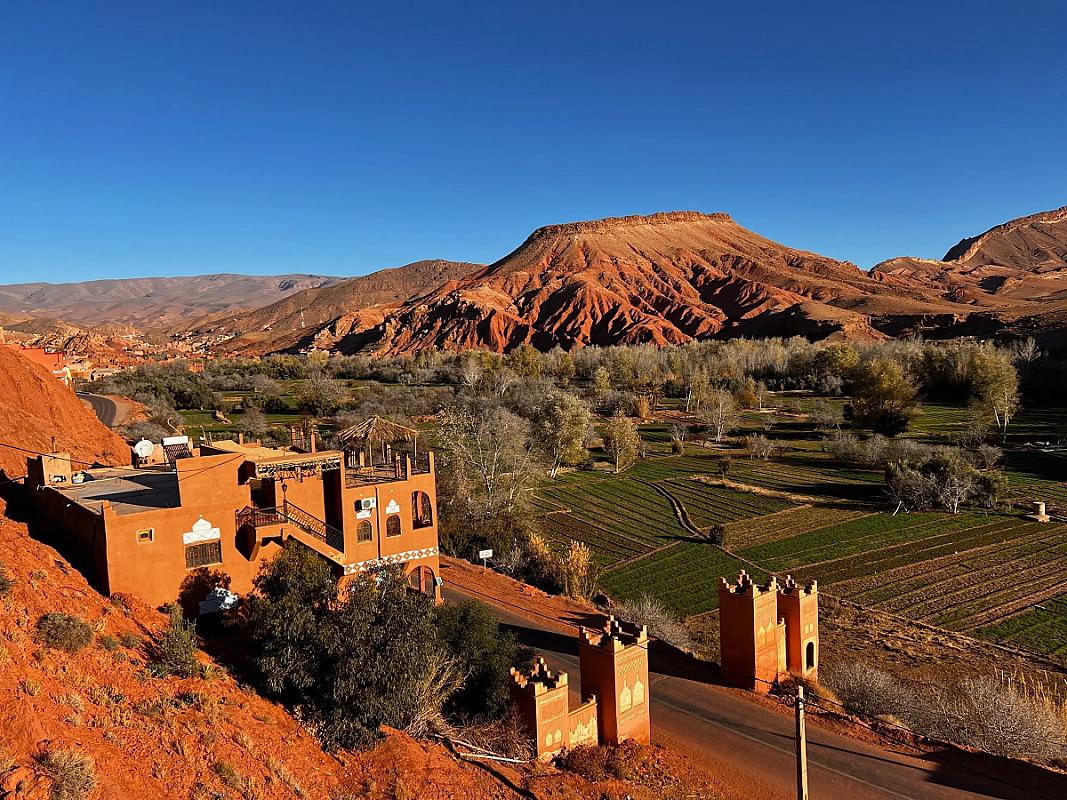 Red hills and green farm plots at the entrance to the Dades valley