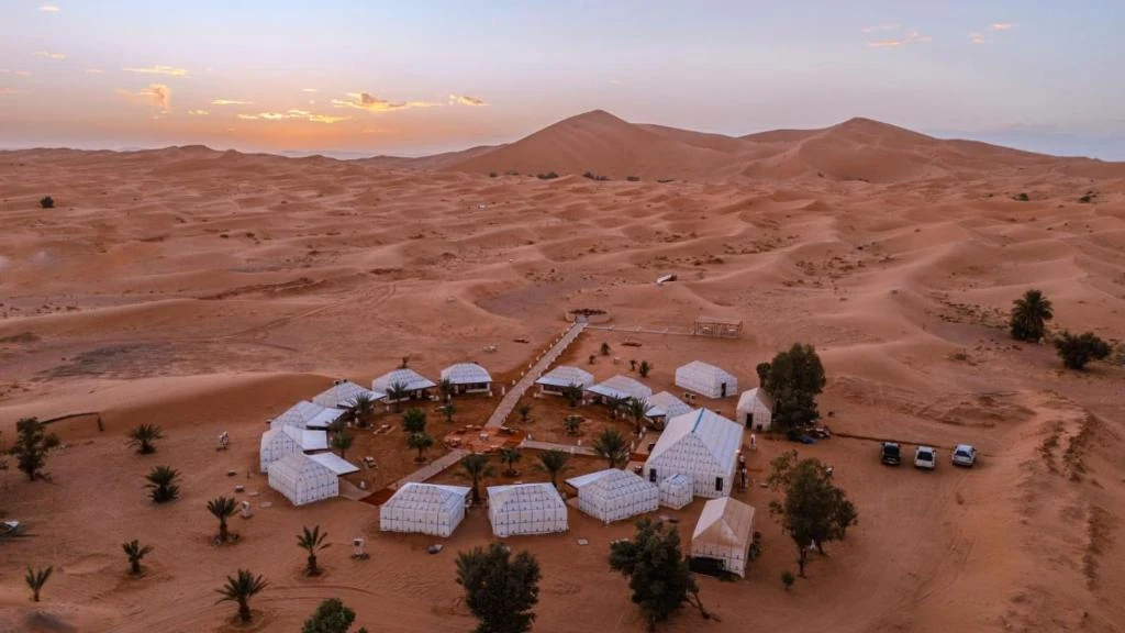Aerial dusk view of a tented camp set in the Merzouga dunes