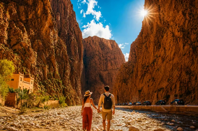 Couple walking the canyon floor between Todra gorge cliffs