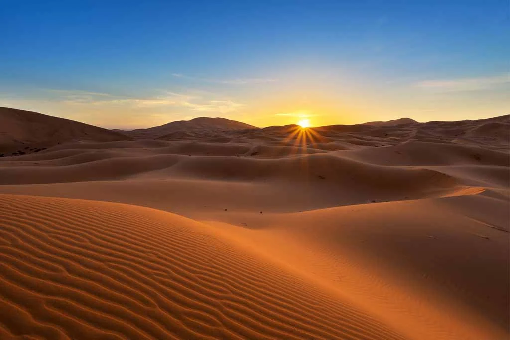 Sun rising over the rippled dunes of Erg Chebbi