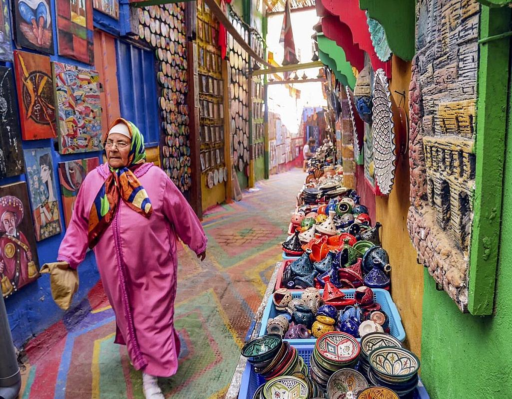 Craft stalls with ceramics and paintings in a Fes medina lane