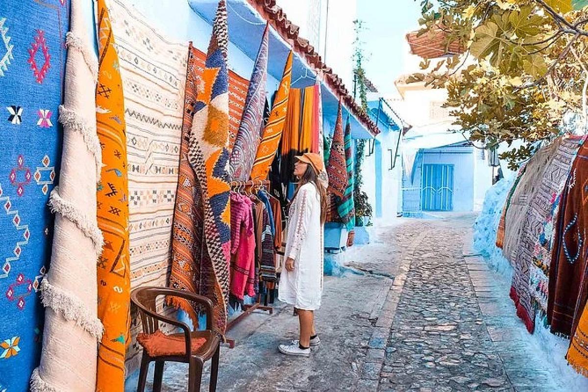 Handwoven rugs displayed along a lane in the Chefchaouen medina