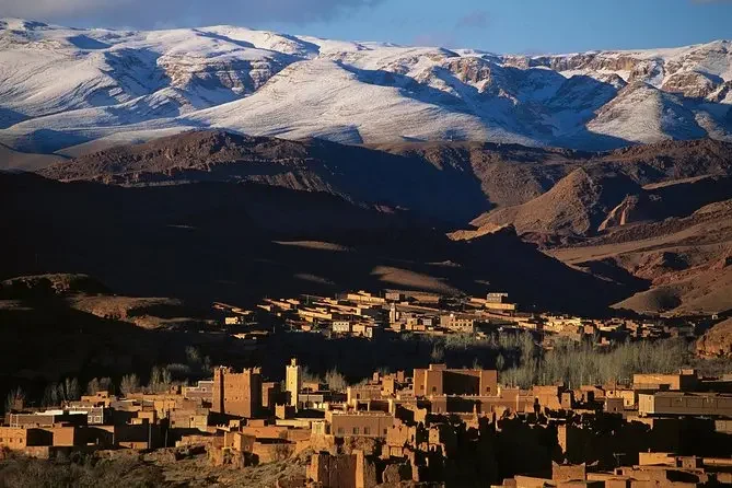 Atlas kasbah below snow-capped peaks
